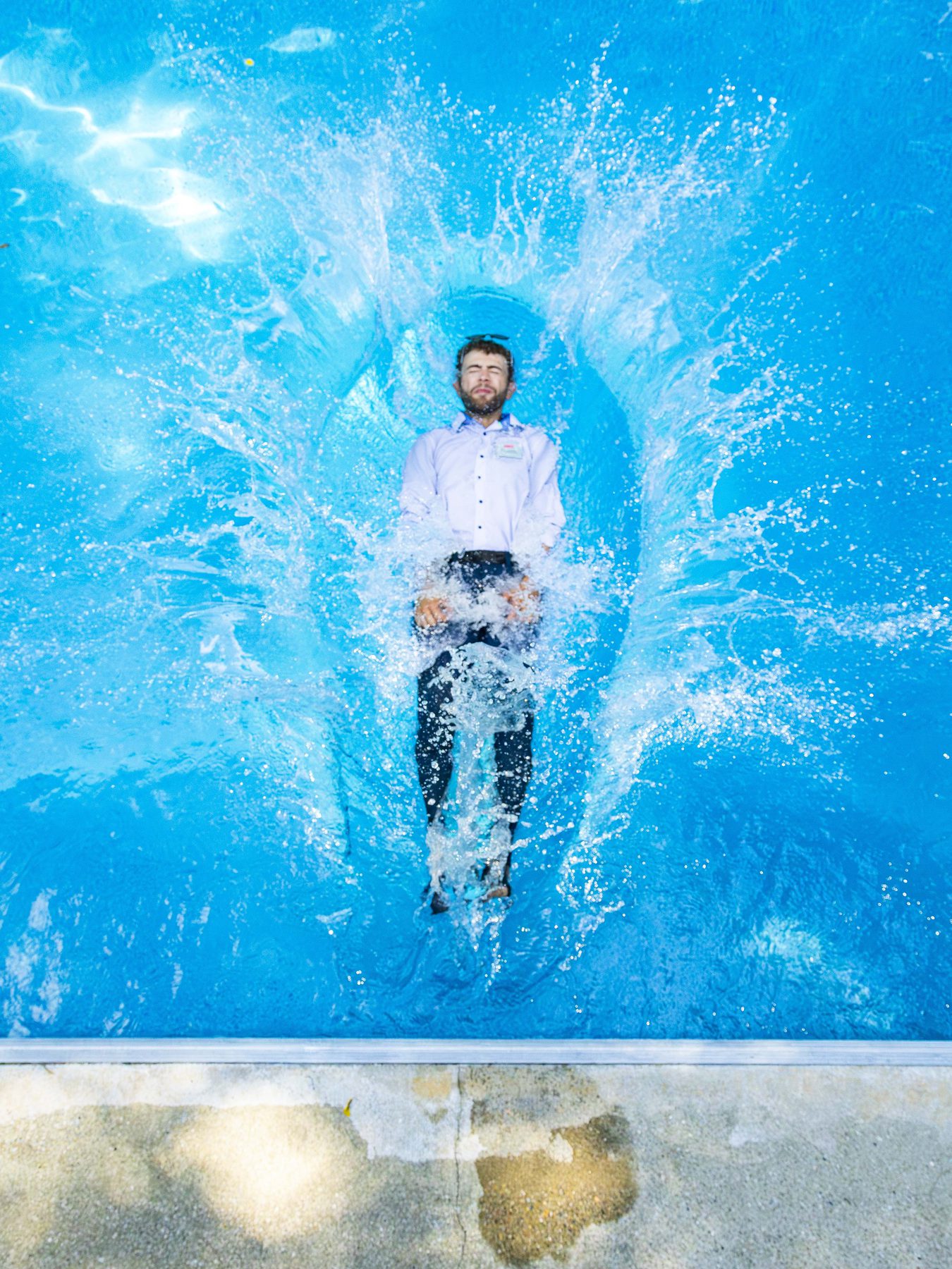 Tom Tranfaglia falling backward into a pool, fully clothed